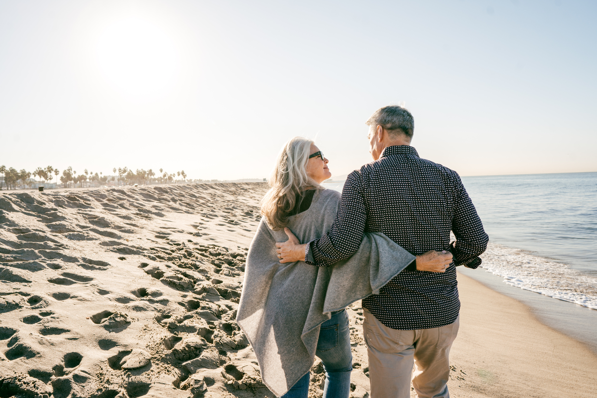 Cost of retirment happiness Middle-aged couple walking along the beach