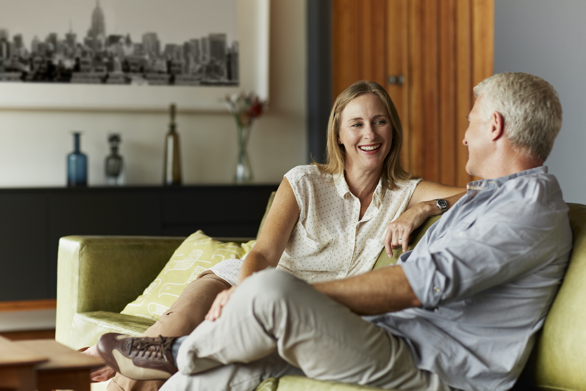 Couple spending leisure time in living room Midlife couple sitting on couch together