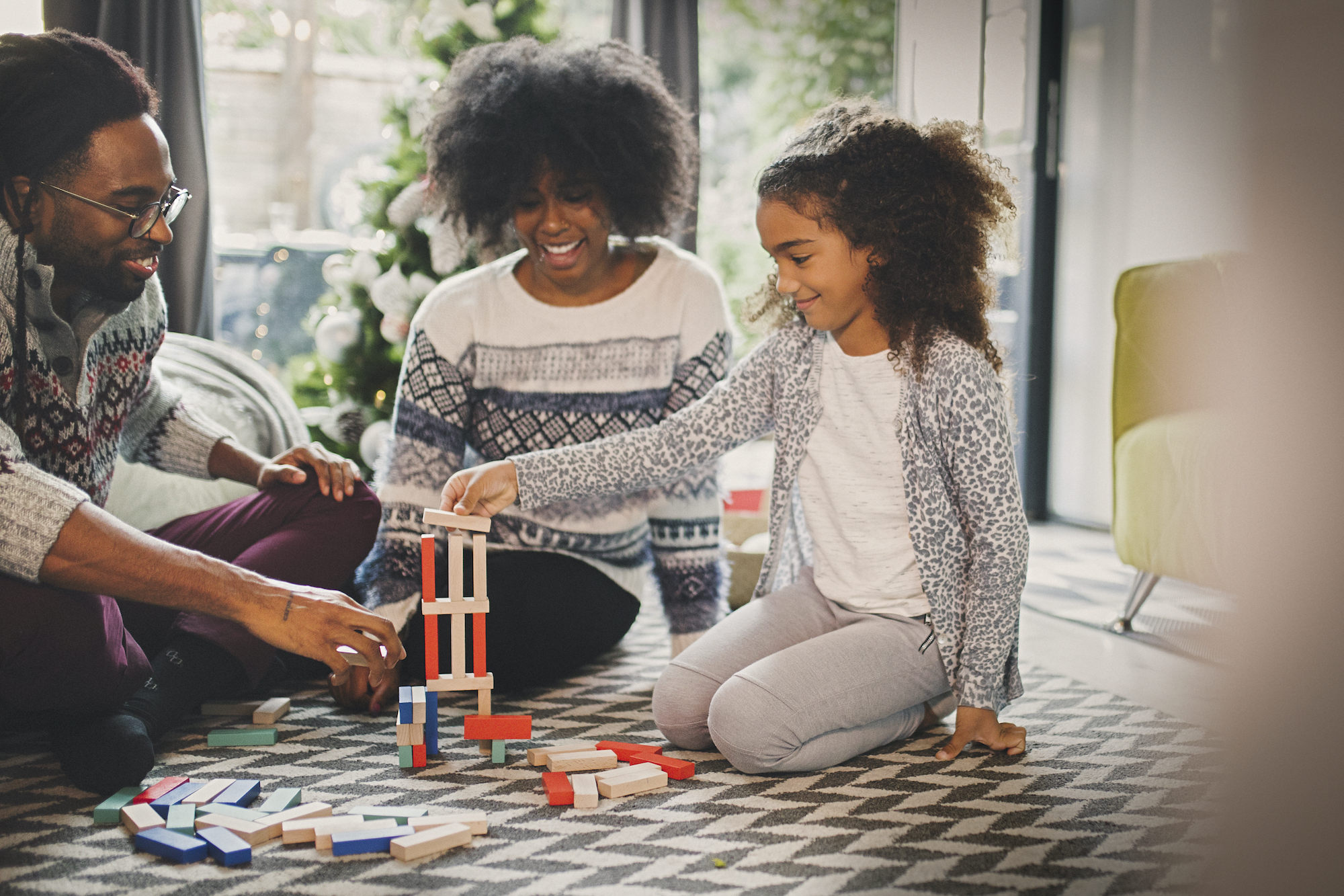 Quality family time Black family plays with blocks in the living room