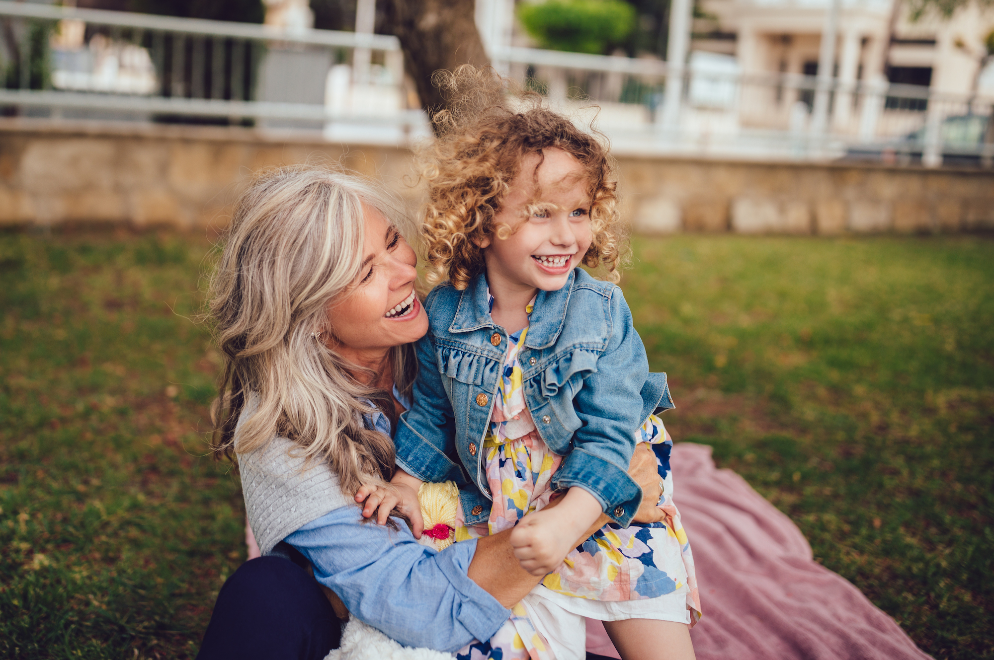 Loving grandmother and granddaughter playing and laughing together in garden Loving grandmother and granddaughter playing and laughing together in garden