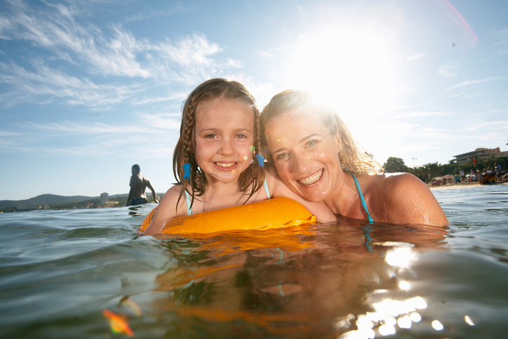 Mother swimming with daughter (7-9) in sea